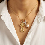 Gold necklace with religious pendants on a white shirt background