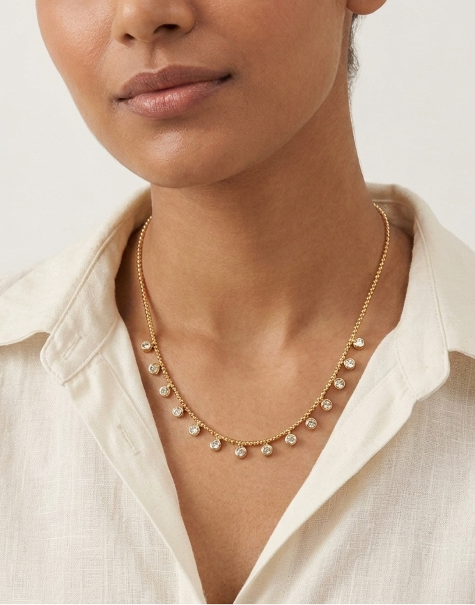 Woman wearing a gold necklace against a plain background