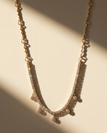 Gold necklace with small diamonds on a beige background