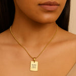 Gold necklace with a pendant on a person's neck