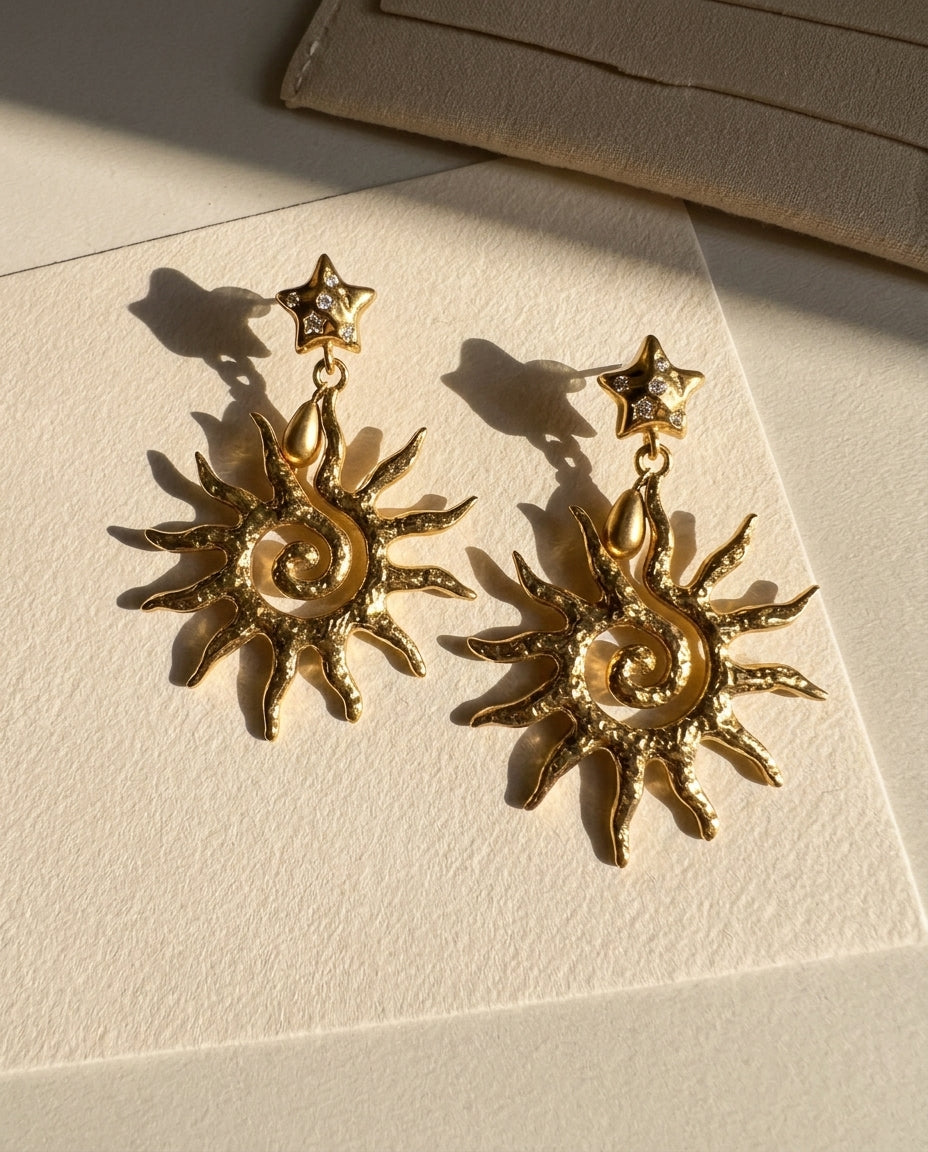 Gold sun-shaped earrings on a beige card