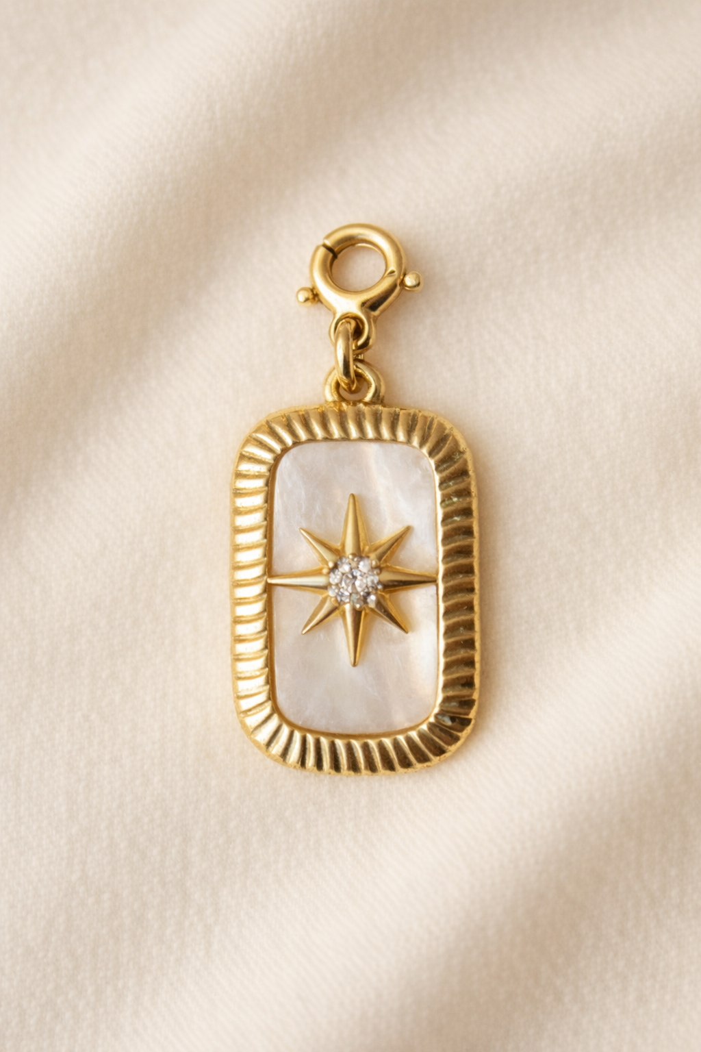 Gold pendant with star design on a beige background