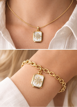 Gold necklace and bracelet with a star-shaped pendant on a person wearing a white shirt.