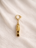 Gold charm on a beige fabric background