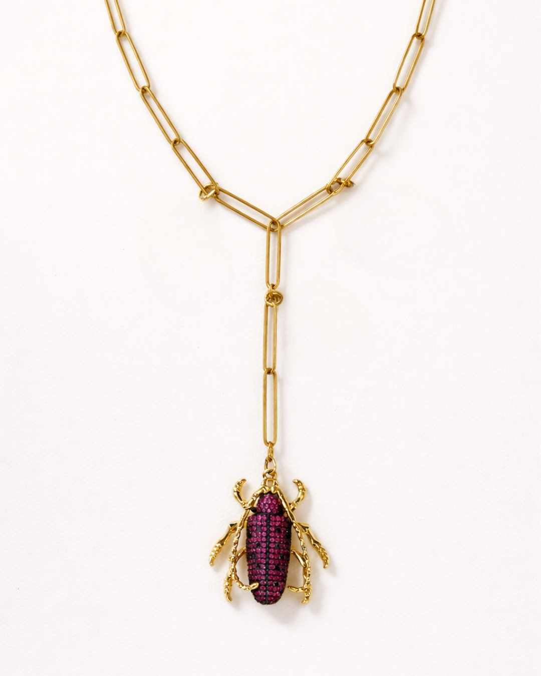 Gold necklace with a beetle pendant on a white background