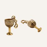 Gold wine glass and bottle charm set on a white background