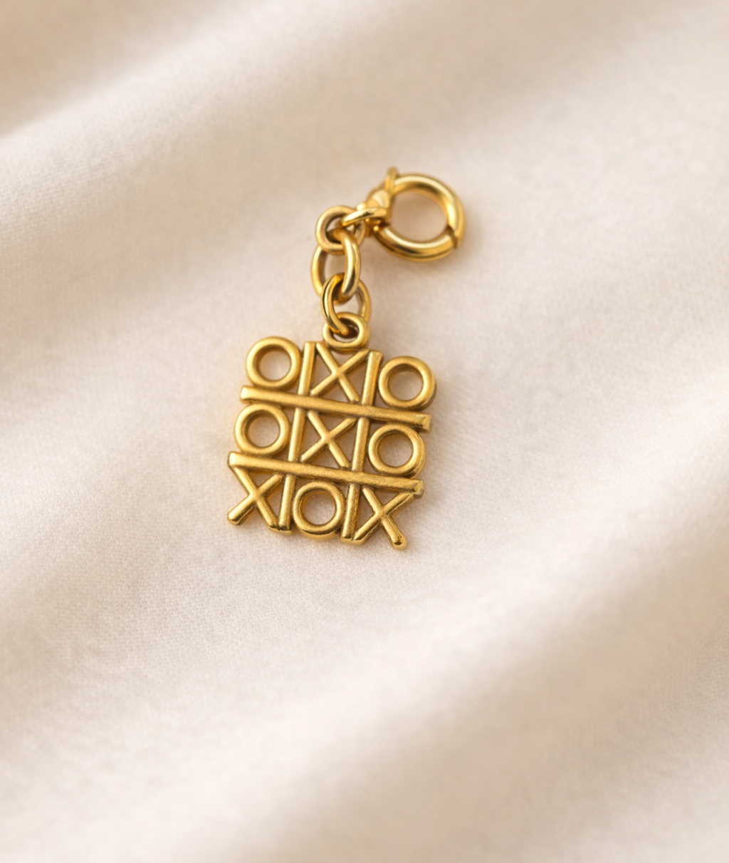 Gold charm with 'OXIO' text on a beige satin background