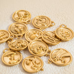 Gold zodiac medallions on a textured white background